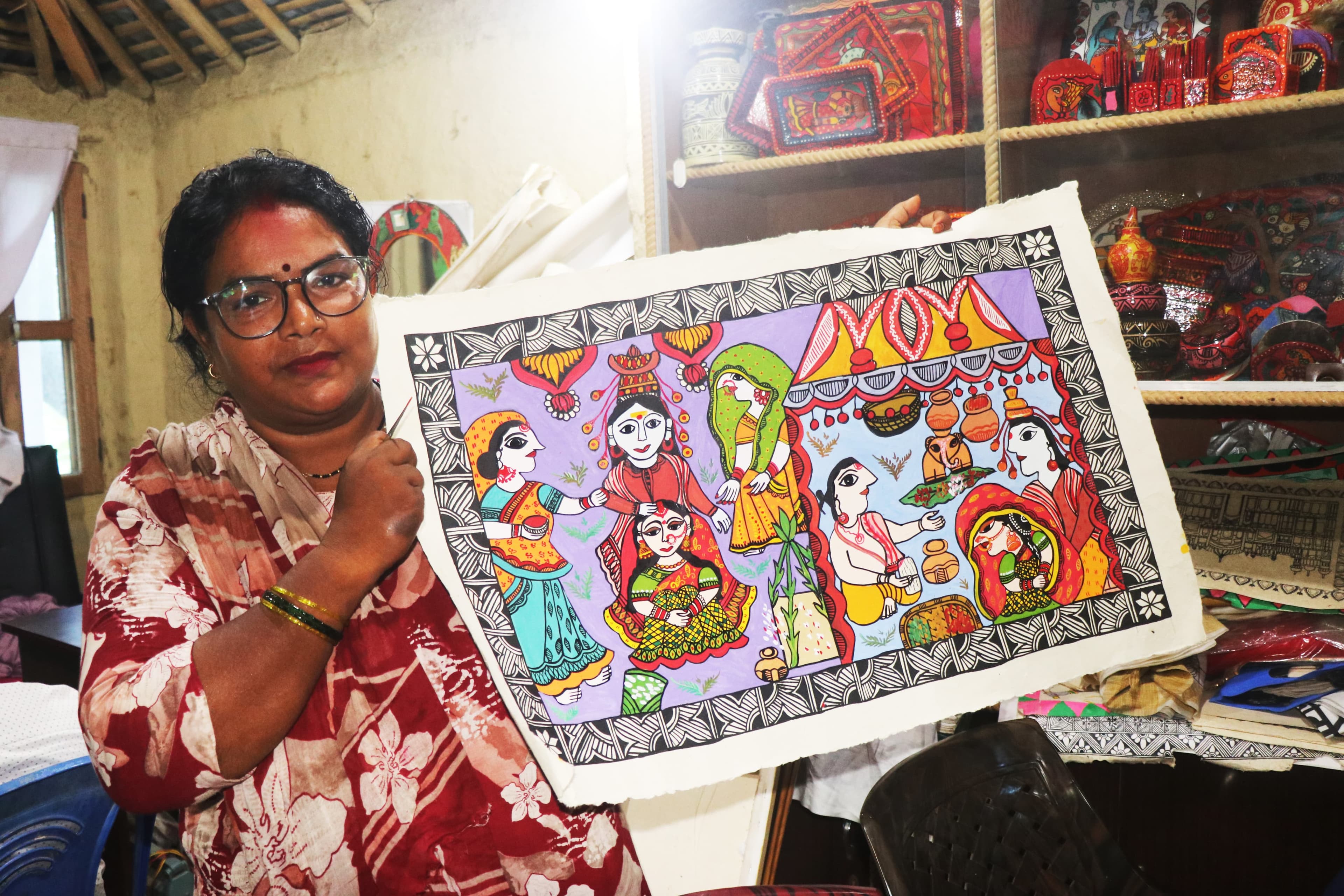 Artist showcasing finished Mithila painting